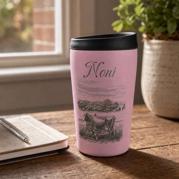 Close-up of Oasis 380ml insulated travel mug with engraved details on rustic wooden table in warm natural light.